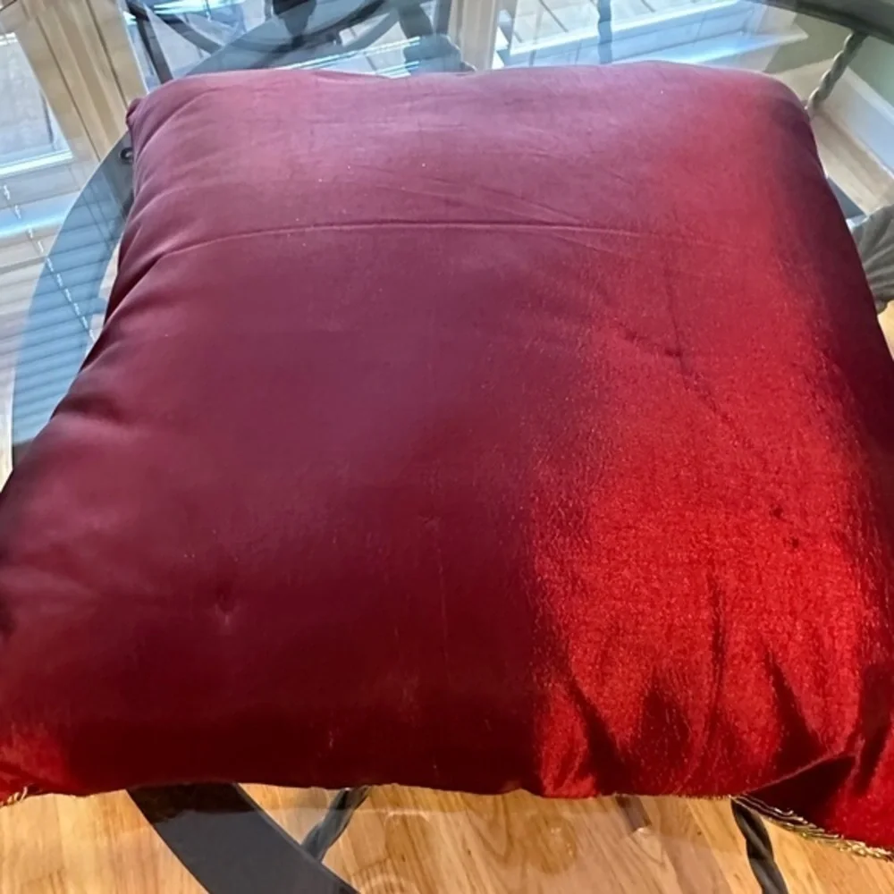Dark red pillow with gold accents